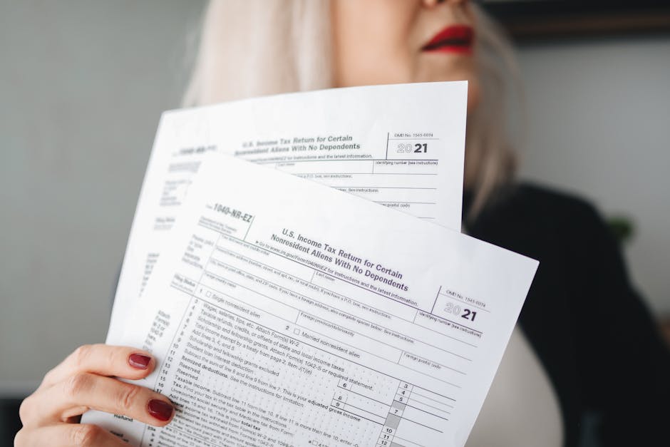 A woman holds U.S. tax documents with a blurred background, implying focus on paperwork.